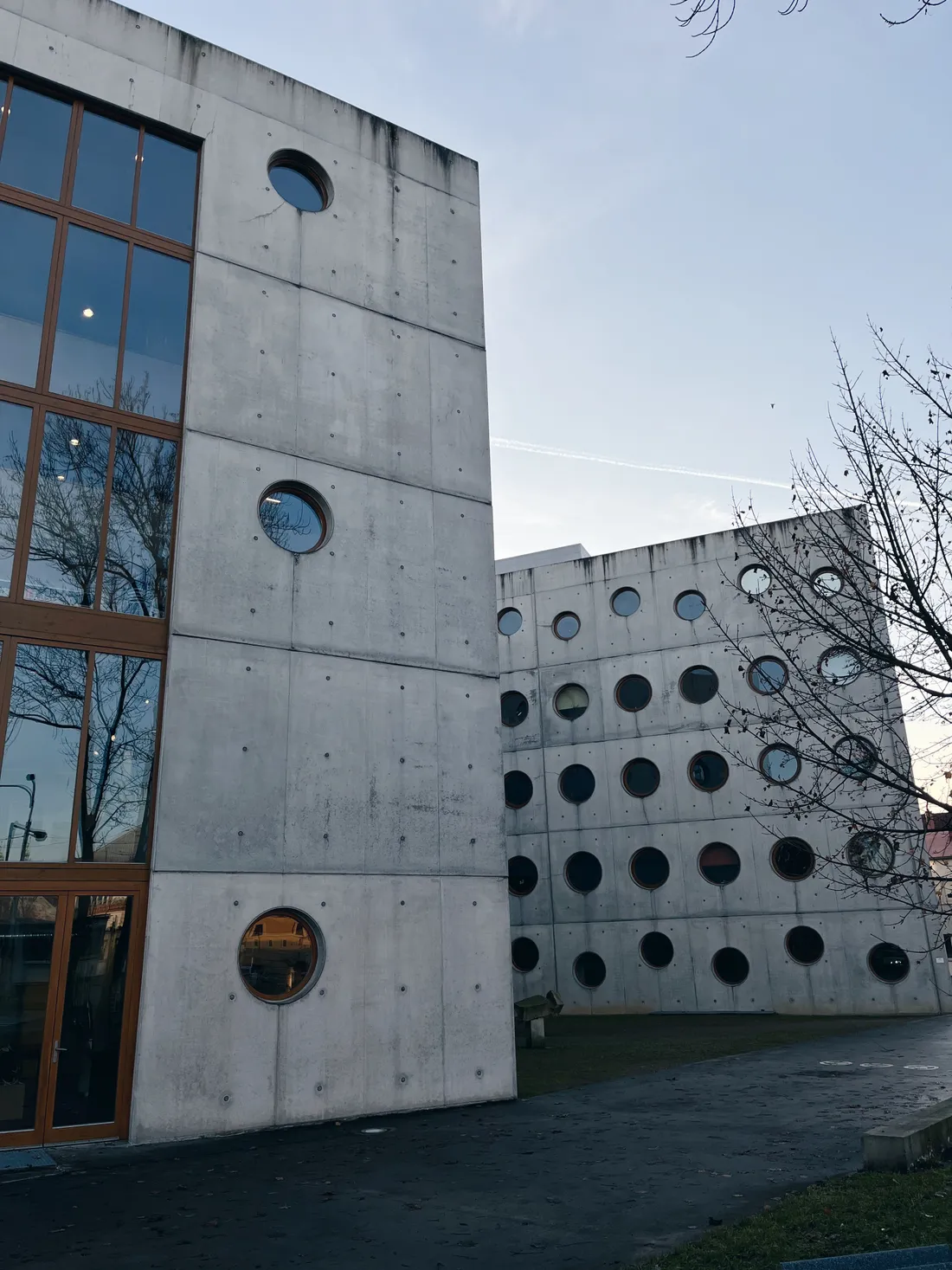 Moderní betonová budova knihovny SVK HK s kulatými okny a velkými skleněnými plochami