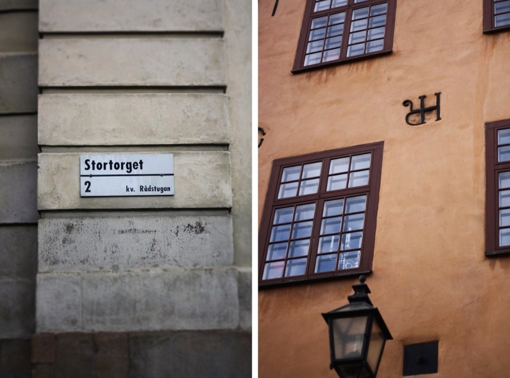Ulice Stortorget ve Stockholmu: cedule na kamenné zdi a oranžová historická fasáda s kovaným detailem.