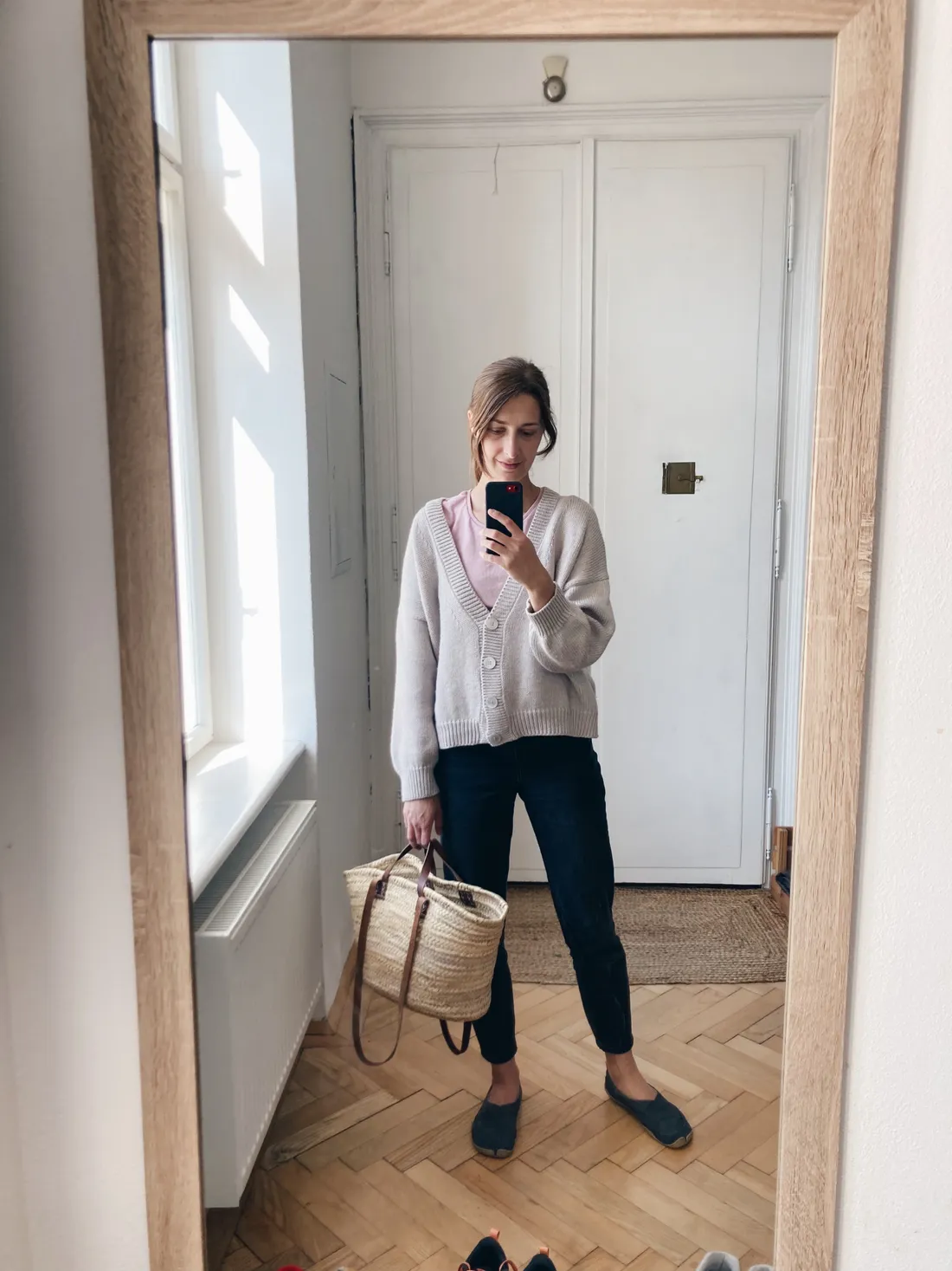 Zrcadlové selfie s šedým oversize kardigánem, růžovým tričkem, tmavými kalhotami, plochými botami a proutěným košíkem