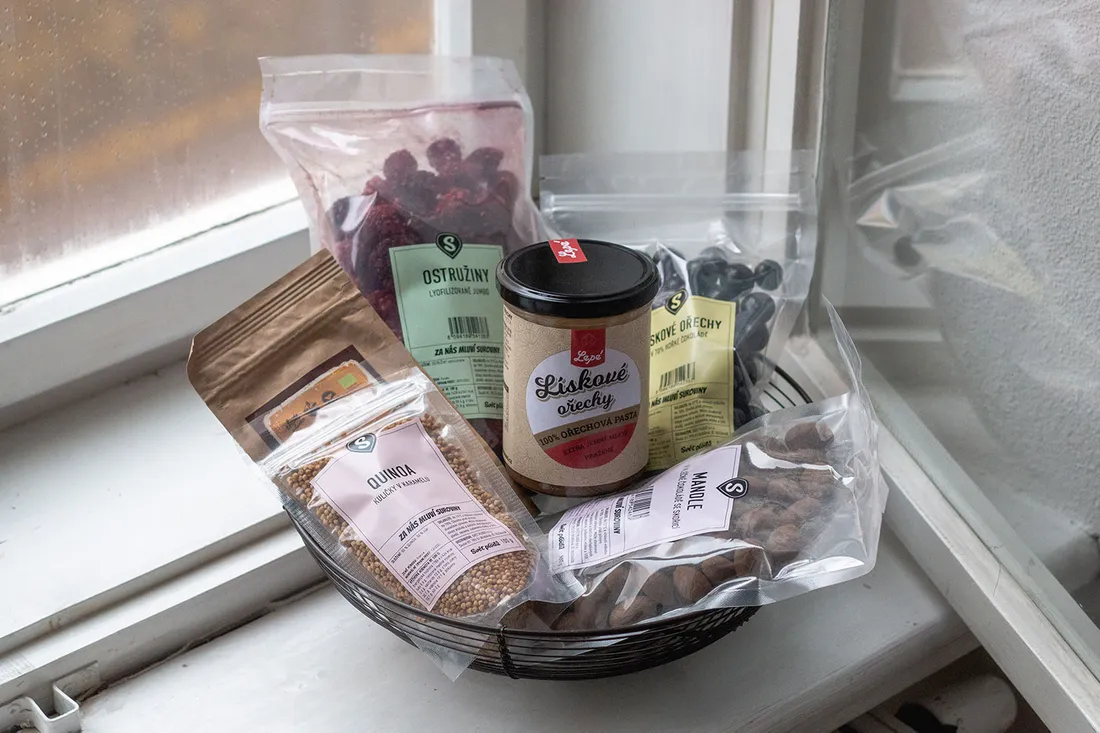 Drátěný košík s produkty Světa plodů – lískooříšková pasta Lépe, lyofilizované ostružiny, quinoové kuličky a mandle