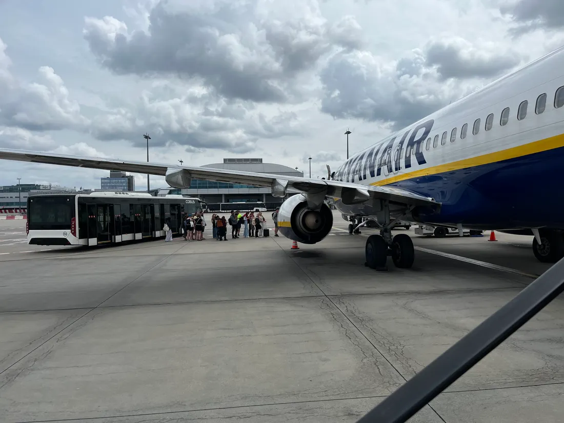 Letadlo Ryanair na letištní ploše s autobusem Cobus a frontou cestujících