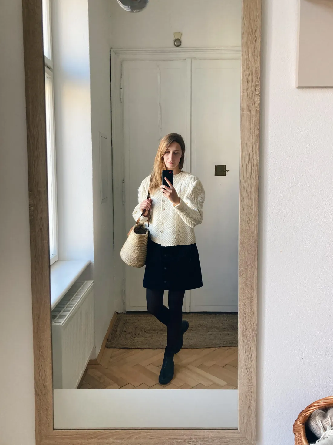 Selfie v zrcadle v krémovém kardiganu, černé sukni a slaměné tašce.