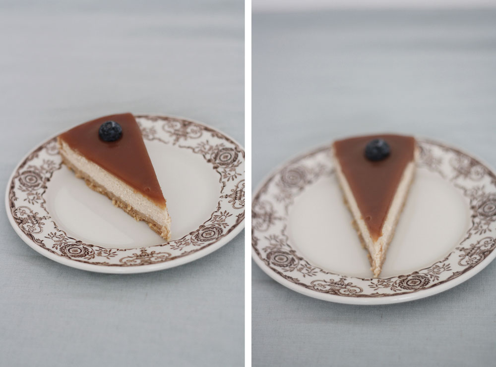 Kus skořicového cheesecakeu se slaným karamelem a borůvkou na vintage talíři se sepia květinovým okrajem.