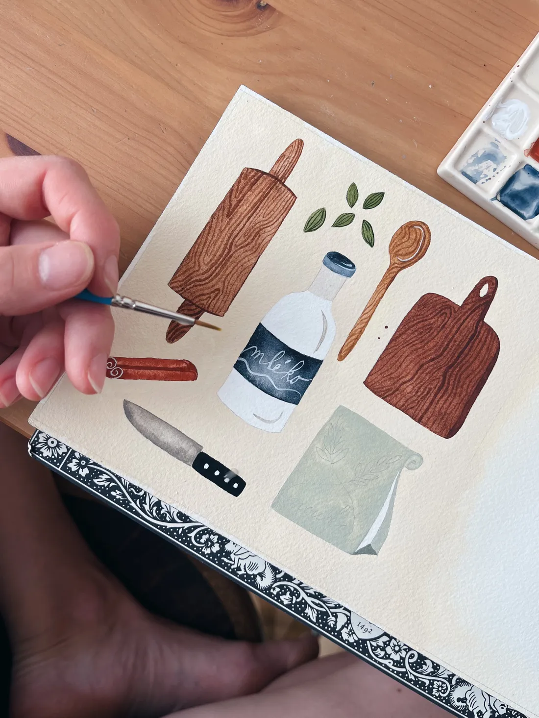Akvarelová ilustrace válečku, lahve mléka, vařečky, prkénka, nože, skořice a kardamomu.