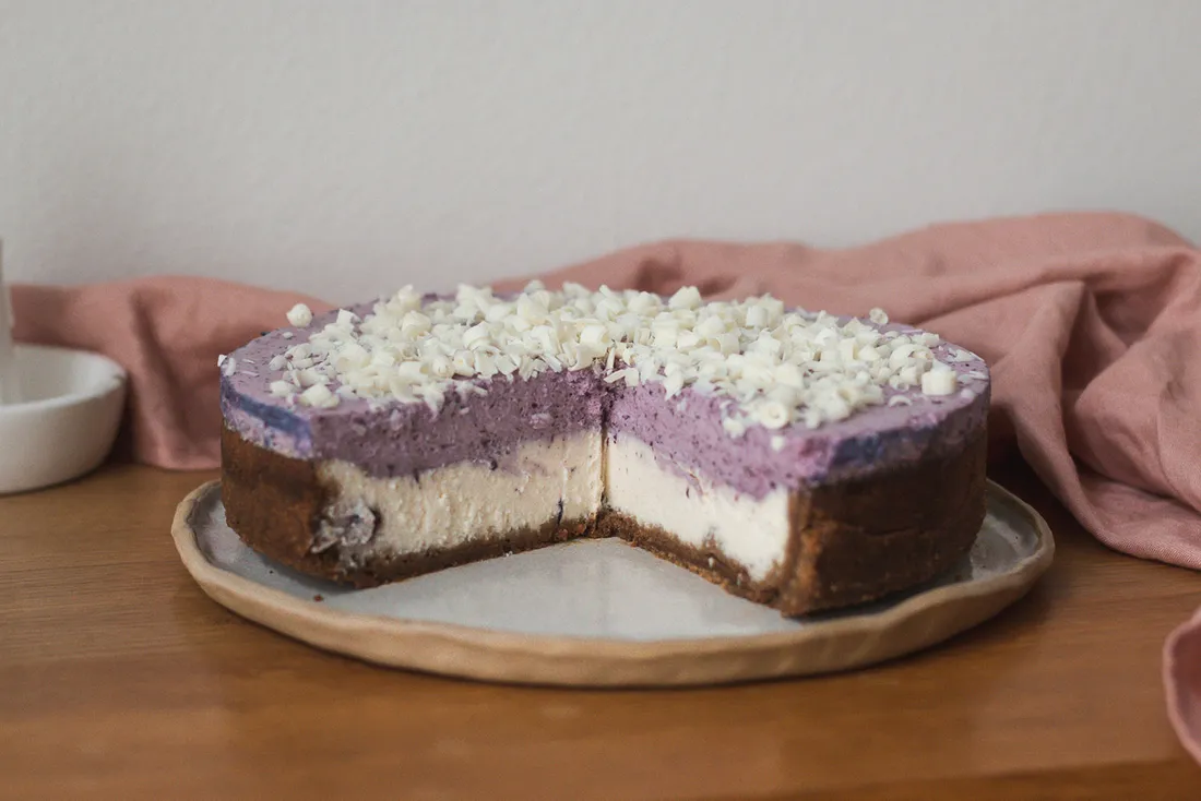 Krémový vanilkový cheesecake s korpusem, který chutná jako slaný karamel, lehounkou pěnou z borůvek a hoblinkami bílé čokolády.